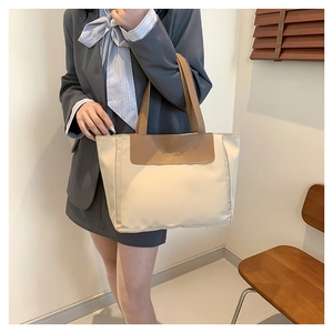 Minimalist cream nylon tote bag with brown handles and fashion embossed flap detail