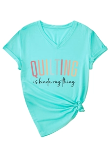 Detail of mint green V-neck T-shirt with 'Quilting' print and stylish hem knot