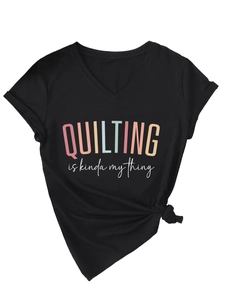 Detail of V-neck black tee showing 'QUILTING is kinda my thing' print and side knot hem