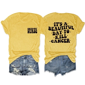 Détail du slogan 'IT'S A BEAUTIFUL DAY TO KILL CANCER' imprimé sur un T-shirt en coton jaune
