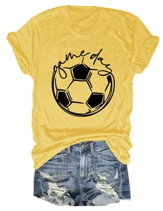 Flat lay of a mustard yellow Game Day football t-shirt with distressed denim shorts