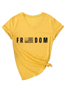 Détail d'un t-shirt col V gingembre avec texte Charlie Kirk et détail d'ourlet noué