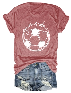Flat lay of a red Game Day T-shirt with a soccer graphic and blue denim shorts