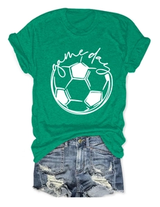 Close-up of green cotton t-shirt featuring soccer print and game day text with denim shorts