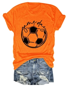 Flat lay of an orange Game Day football t-shirt paired with ripped denim shorts