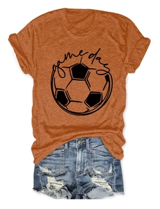 Close-up of orange Game Day football t-shirt paired with denim shorts on white background