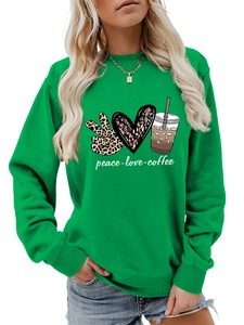 Close-up of the Peace Love Coffee print and fabric texture on a green sweatshirt