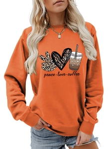 Detail of peace love coffee graphic print on an orange crewneck sweatshirt