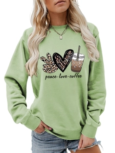 Close-up of bohemian peace love coffee print on light green crewneck sweatshirt fabric