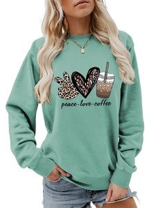 Detail of mint green sweatshirt with leopard peace sign, heart and coffee cup graphics