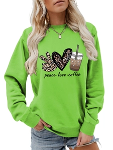 Detailed view of the ribbed round neckline and graphic print on the green sweatshirt