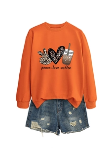 Flat lay of an orange sweatshirt with peace love coffee print and blue denim shorts