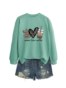 Detail view of mint green sweatshirt with peace love coffee print and ripped denim shorts