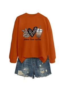 Macro shot of peace love coffee graphic on rust orange sweatshirt with ribbed cuffs