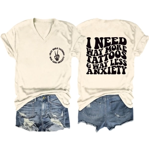 Flat lay of cream V-neck tee with large back graphic and distressed denim shorts