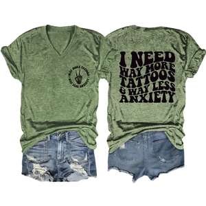 Green V-neck T-shirt with 'I NEED WAY MORE TATTOOS' slogan text and denim shorts