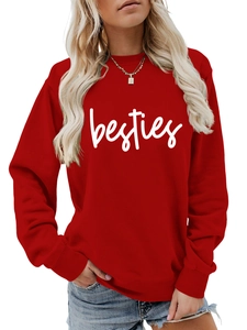 Close-up of red crewneck sweatshirt featuring white besties script print and ribbed collar