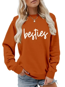 Close-up of caramel orange crewneck sweatshirt featuring white besties script printing