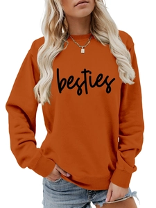Detail of orange crewneck sweatshirt with black besties cursive print and ribbed cuffs