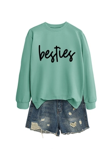 Detail of mint green sweatshirt with besties script text and ripped denim shorts