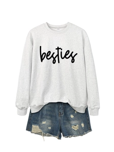 Detail of grey crewneck sweatshirt with black besties print and ripped denim shorts