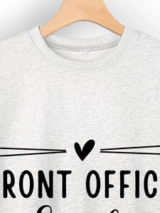 Close-up of light gray sweatshirt featuring black FRONT OFFICE lettering and heart graphic