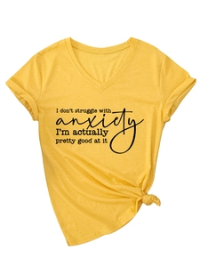 Detail of yellow V-neck t-shirt showing knotted hem and humorous printed text quote