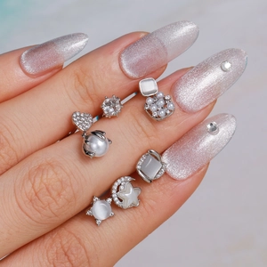 Zilveren oorbellen set met parels en zirkonia vastgehouden door hand met glitter