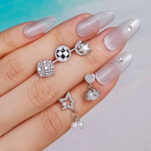 Minimalistische parel en zirkoon oorknopjes set op zilveren nagels bij het strand