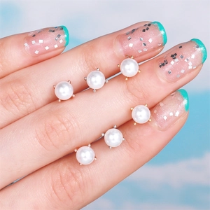 Detailed close-up of a six-piece set of round pearl earrings with gold and silver stud bases