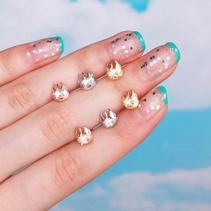 Star earrings with zircon stone in gold, silver, and rose gold on a blue sky background