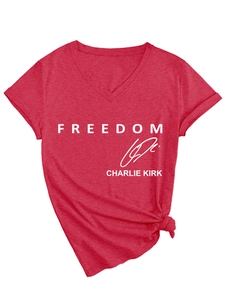 Detail of red V-neck t-shirt with white Freedom print and Charlie Kirk signature knot