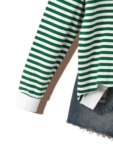 Detail of green and white striped long sleeve top with blue frayed denim skirt laid flat
