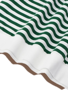 Detail of green and white striped knit fabric with ribbed hem and high-quality stitching