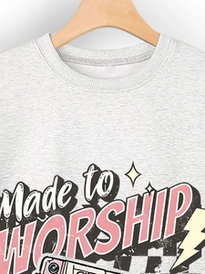 Detail of grey crewneck sweatshirt with vintage Made to Worship print and ribbed collar