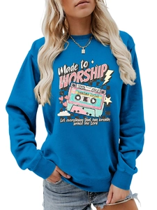 Detail of blue crewneck sweatshirt featuring a retro cassette print and religious text