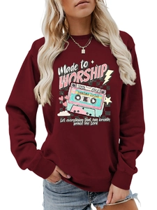 Detail of burgundy sweatshirt featuring retro cassette tape and religious print