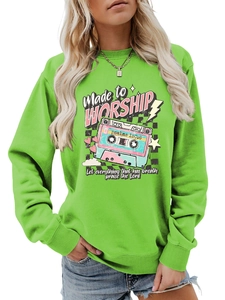 Close-up of neon green sweatshirt featuring retro cassette tape print and religious text