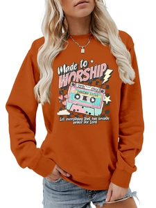 Detail of burnt orange sweatshirt showing vintage cassette tape print and ribbed neckline