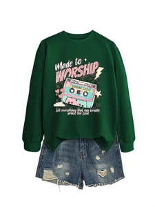 Flat lay of green sweatshirt with vintage tape print and distressed denim shorts