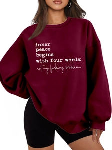 Detail of burgundy oversized hoodie showing soft cotton texture and white slogan print