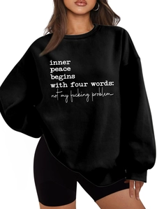 Detail of black crewneck sweatshirt featuring white slogan print inner peace begins with
