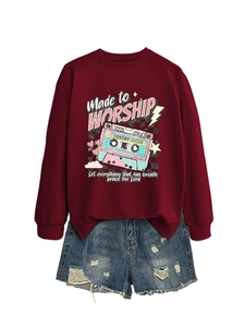 Flat lay of maroon pullover with retro cassette print and distressed denim shorts