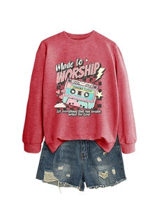 Detail of red crewneck sweatshirt with retro cassette graphic and distressed denim shorts
