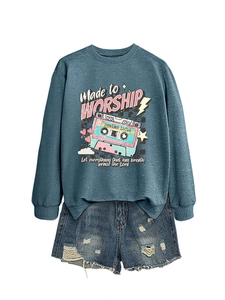 Flat lay of blue-grey sweatshirt with vintage tape print and ripped denim shorts