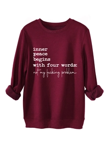 Detail of burgundy fleece sweatshirt with inner peace slogan on white background