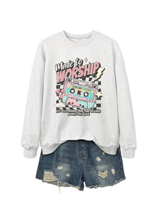 Flat lay of gray sweatshirt with vintage cassette graphic and distressed denim shorts