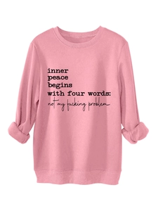 Close-up of pink thick hoodie with black typography print Inner peace begins text