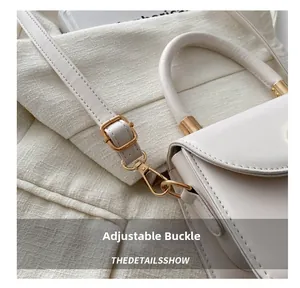 Detail of adjustable buckle and golden lobster clasp on beige crossbody leather handbag