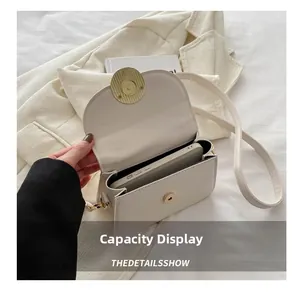 Detail display of the cream white crossbody bag with magnetic closure and phone capacity
